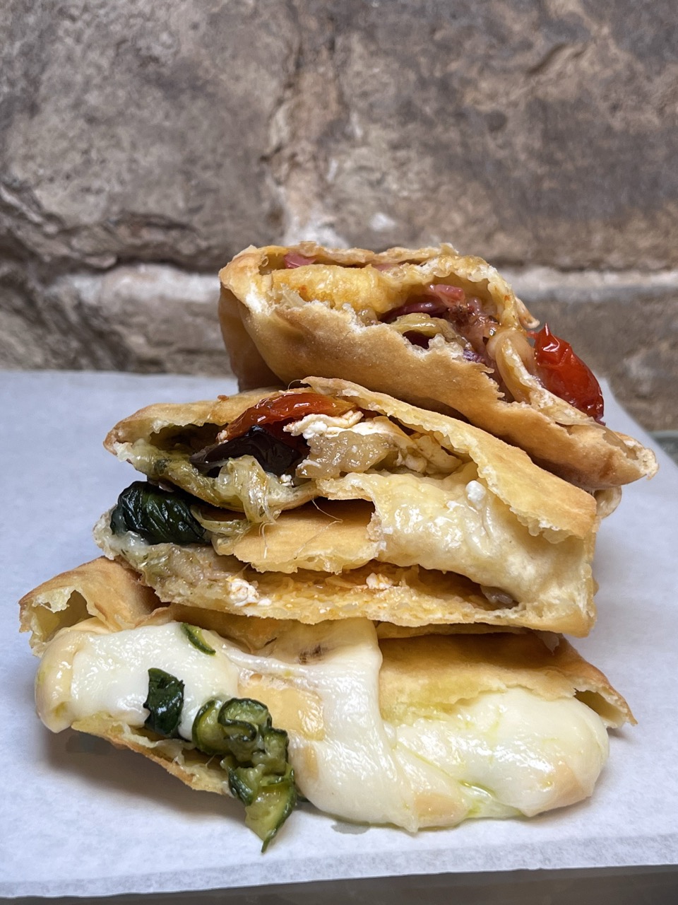 Panzerotti baresi tagliati a metà con ripieno di verdure e mozzarella filante da Panzeropoli
