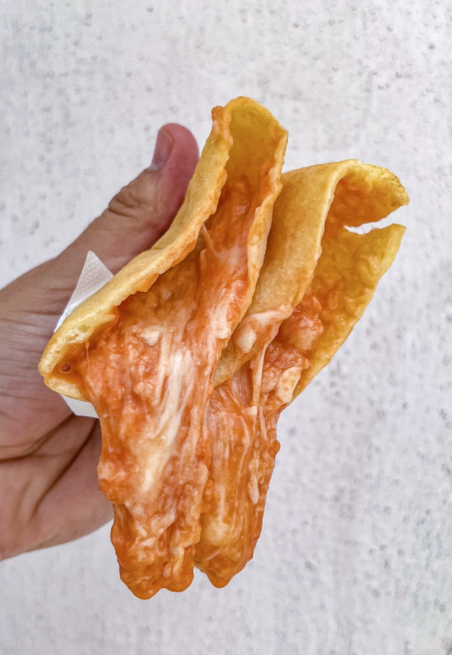 Panzerotto barese aperto a mano con pomodoro e mozzarella filante, street food a Bari Vecchia