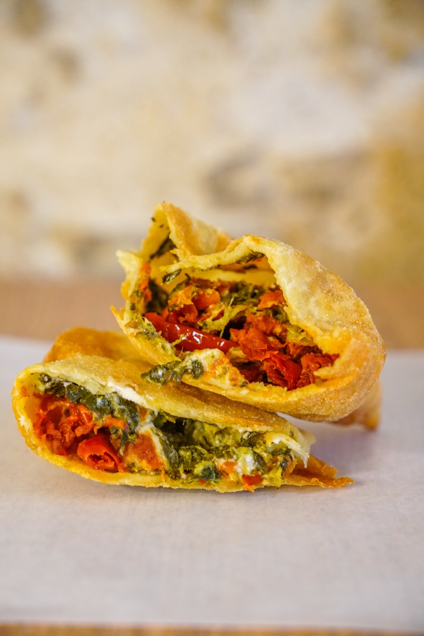 Panzerotto vegano barese tagliato a metà con ripieno di verdure e pomodori da Panzeropoli